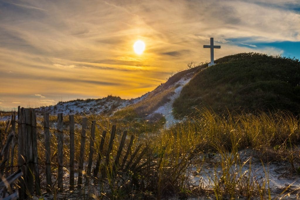 cross at sunrise on beach-side 