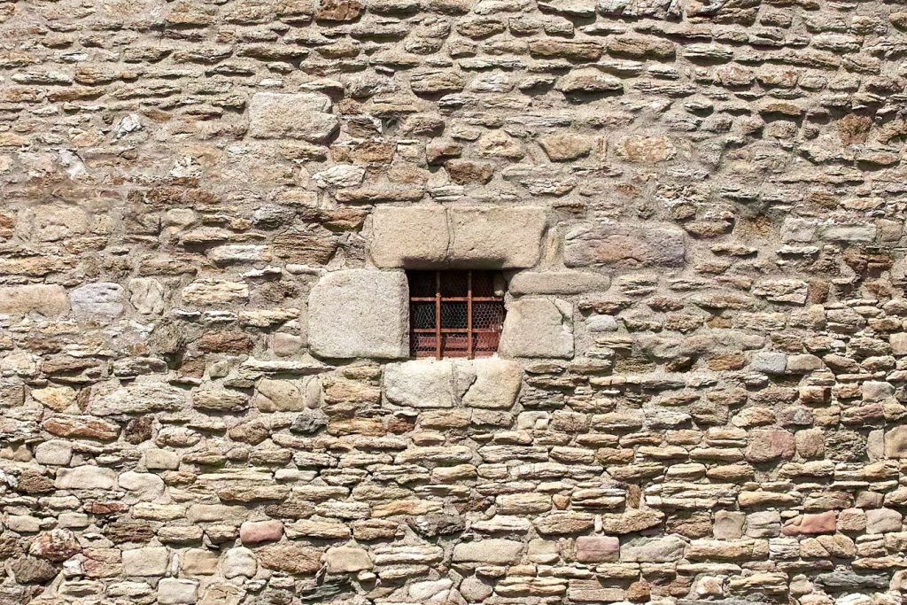 jail window on outside of stone building
