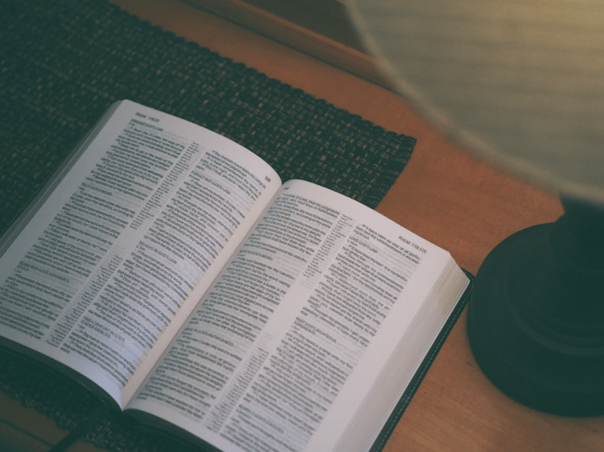 Bible opened on desk with lamp