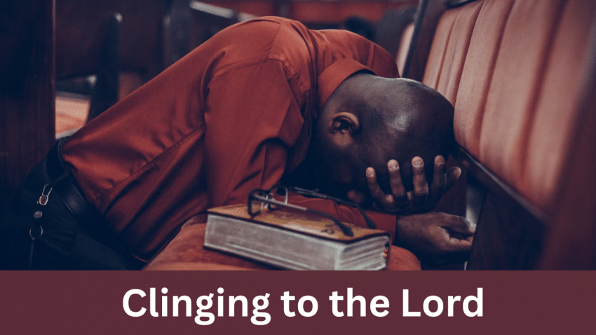 Person praying with head bowed on church pew with Bible next to them, with the words "Clinging to the Lord"